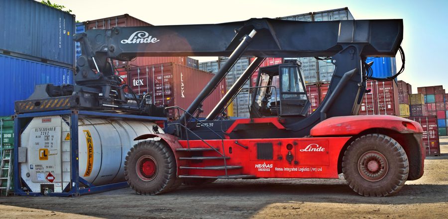 Reach stacker lifting an oversized container at port